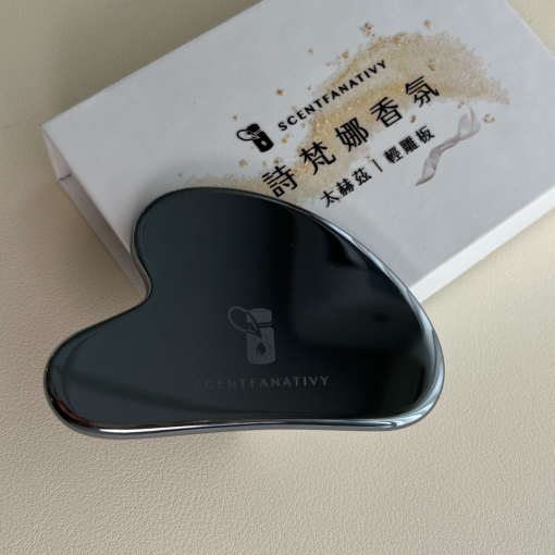 SCENTFANATIVY 太赫茲刮痧板，拍攝於質感布料背景。光滑圓潤的邊緣設計貼合臉部與身體曲線，適合美容護理與日常養生。太赫茲石質地細膩，能搭配精油或乳液，帶來舒緩放鬆與肌膚保養功效。