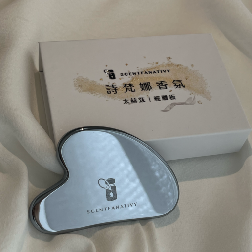 SCENTFANATIVY 太赫茲刮痧板（銀色款），搭配品牌專屬禮盒拍攝。太赫茲石材質光澤晶亮，觸感涼感細膩，能幫助臉部與身體按摩，促進循環、舒緩緊繃。刮痧板造型貼合肌膚曲線，適合美容保養與日常養生使用，搭配精油或乳液效果更佳。
